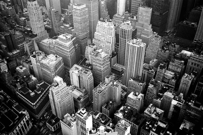 Black-and-white aerial of a dense city, roofs packed like type.