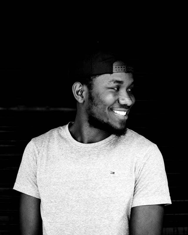 Black-and-white fashion still, cap and black knit.
