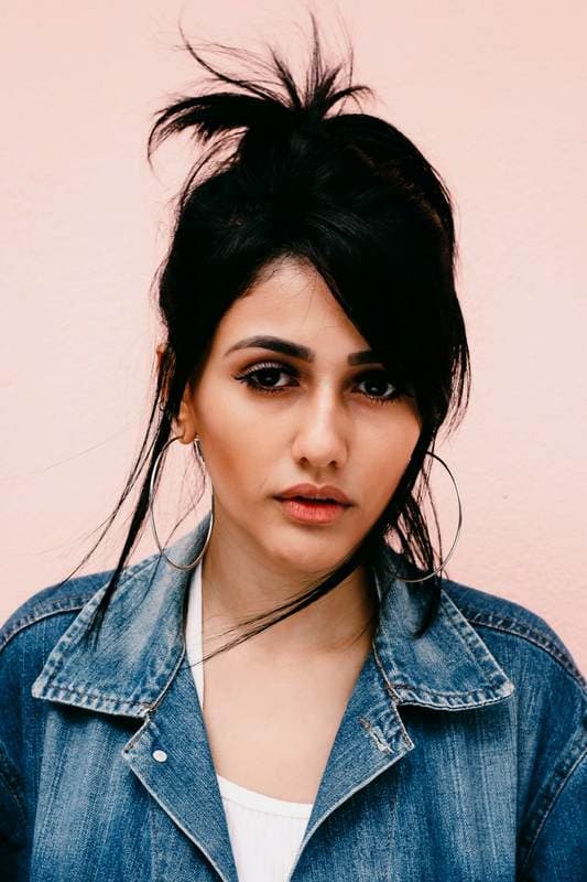 Close face, hair forward, looking past the camera.